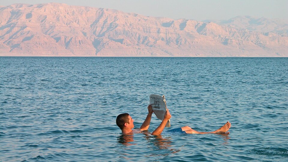 man floating in dead sea with newspaper tb100403503 1